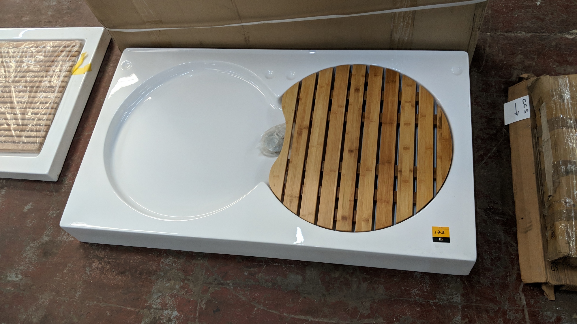 Large white shower tray with wooden slatted circular removable board