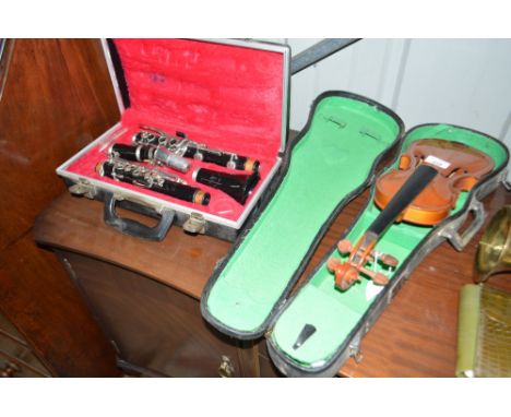 A small size violin in carrying case; and a Boosey and Hawkes clarinet in carrying case