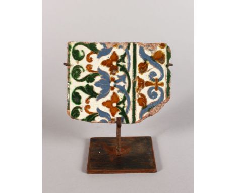 A FRAGMENT OF AN ISLAMIC TILE on a metal mount.