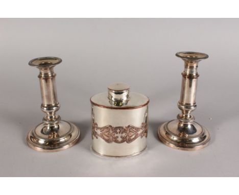 A PAIR OF TELESCOPIC CANDLESTICKS and A TEA CADDY.