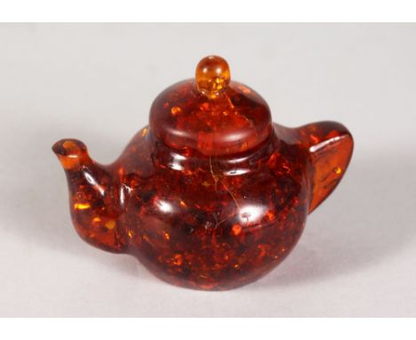 A SMALL AMBER TEAPOT. 2.5ins high.