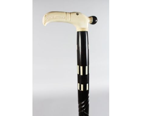 A WALKING STICK WITH BONE BIRD HEAD HANDLE.