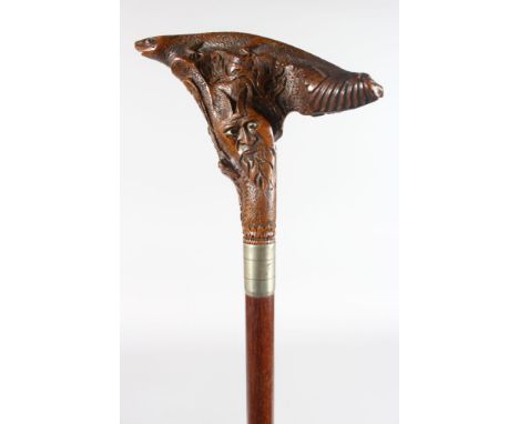 A WALKING STICK with carved wooden HEAD AND FISH handle.