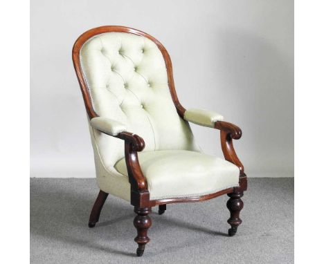A Victorian green upholstered button back armchair, on turned legs