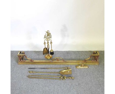 A brass fender, together with a companion set and fire tools