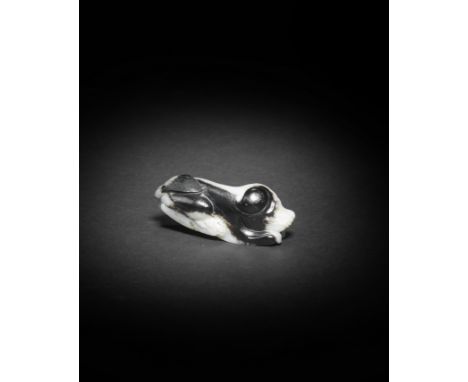 A WHITE AND BLACK JADE CARVING OF A DOGMing DynastyThe recumbent animal, with its head resting on its front paws, with two la
