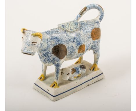 An earthenware, cow and calf model, Staffordshire or Yorkshire, 1800-1820, modelled with a calf, the cow black patched with b