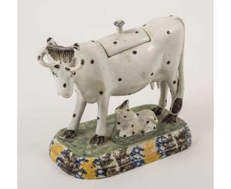 An earthenware polka dot cow creamer, probably Staffordshire, circa 1800, model with a calf, the lid replaced or extensively 