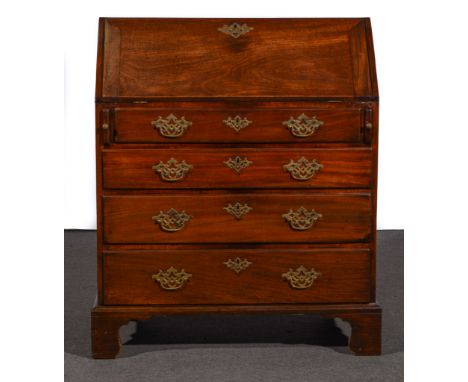 A George III mahogany bureau, fall front enclosing a fitted interior with a cupboard, pigeon holes and drawers, four long gra