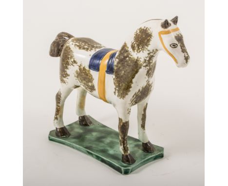 A Pearlware model of a saddled horse, attributed to St. Anthony Pottery, Newcastle, circa 1800, in curved green wasted base, 