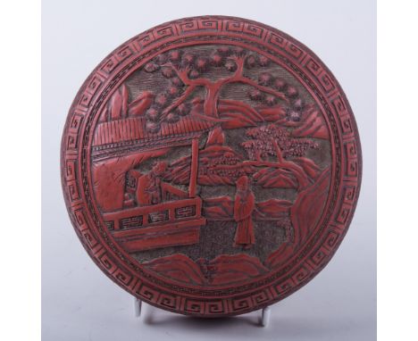 A Chinese cinnabar lacquer box, probably 19th century, cushion circular form, decorated with figures in a garden setting, dia