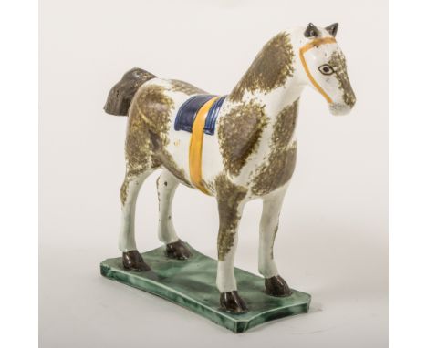 A Pearlware model of a saddled horse, attributed to St. Anthony Pottery, Newcastle, circa 1800, in curved green wasted base, 