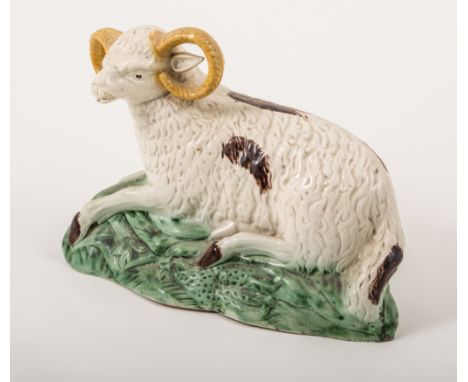 A Pearlware hollow-base model of a recumbent long-horned ram, perhaps Newcastle, circa 1800, slightly domed, a section restor