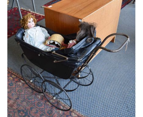 A Vintage Dolls Pram, with folding canopy, leaf sprung and on spoked wheels, together with a German bisque head doll with com