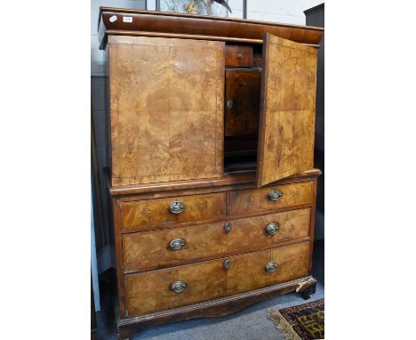 A Figured Walnut Escritoire, early 18th century, with quarter veneered and feather banded doors opening to reveal a fully fit