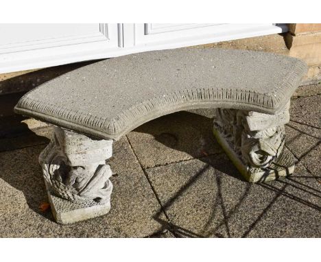 A Composite Curved Garden Bench, raised on dolphin-formed pedestals, 104cm by 46cm by 40cm