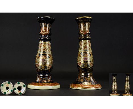  A Pair of Oriental Candlesticks two earthenware candlesticks of pillar form, raised on circular bases. The whole decorated i