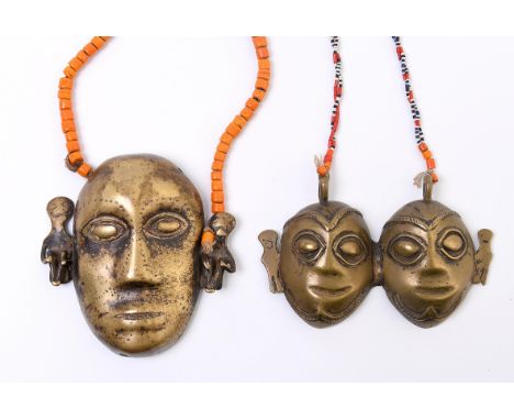 North East India, Naga, a brass pectoral in the form of an anthropomorphic head. Herewith a brass pectoral of a pair of heads