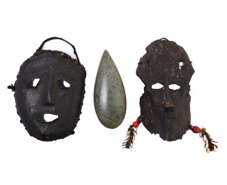 A metal face mask and a mask made from a animal skull. Hereby a green stone axe-head, possibly Asmat. L. 20 and 24 cm. [3]