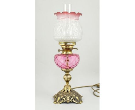 Victorian style table lamp, ruby tinted and moulded shade and reservoir with chimney, cast brass base, converted to electrici