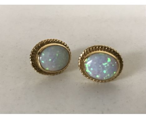 A pair of yellow gold mounted opal earrings. (2)