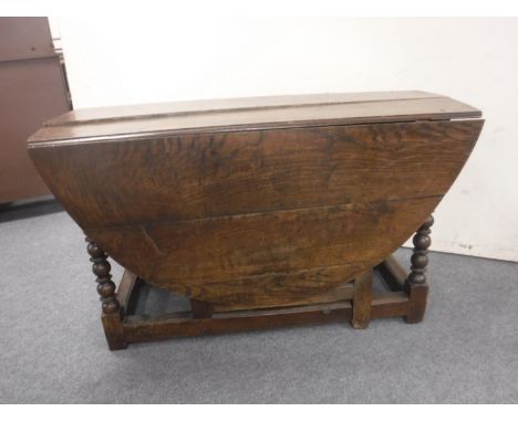 An antique oak gate leg table fitted two drawers 