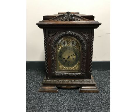 A carved oak chiming bracket clock with brass dial 