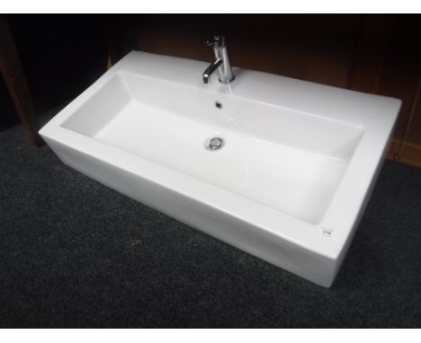 A large double ceramic hand basin with taps