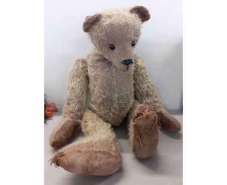 An early 20th century straw filled teddy bear with long nose, boot button eyes in the Steiff style A/F 