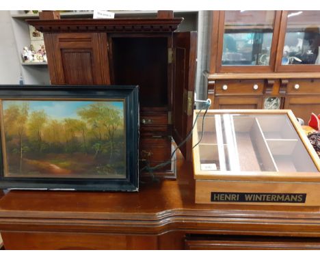 An early 20th century oak Army & Navy smokers cabinet with carved panelled doors over two drawers, an oil on canvas and a Hen