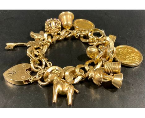 A 9ct gold charm bracelet full of charms, to include a 9ct gold mounted 1912 full sovereign coin and a 9ct gold mounted 1906 