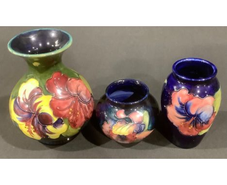 A Moorcroft Hibiscus pattern vase, paper label, 13cm; an Hibiscus pattern vase, 10.5cm; an Orchid pattern ovoid vase, 7cm (3)