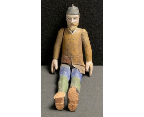 A German painted wooden folk art doll, with carved painted body, breaded face, black hat, 19cm high