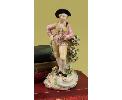 A Derby patch mark figure, of a gallant, he stands wearing a tricorn hat, pink jacket and yellow breeches, holding a love let
