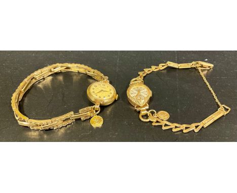 Two Vintage 9ct gold ladies Rotary watches, one of them with a round watch face with a bow design and stretchable watch brace