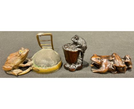An Edwardian lacquered brass novelty pin cushion, modelled as a frog looking at a fly, 8cm wide; a Japanese carved hardwood n