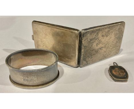 A silver matchbook holder, 6.5cm long, Birmingham 1920; a silver napkin ring, Birmingham 1948; a silver locket, Birmingham 19