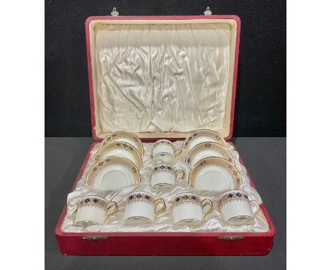 An early 20th century Cauldon coffee set for six, decorated in the Imari style, picked out in gilt, each can 5cm high, cased