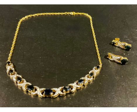 A silver gilt graduated sapphire and diamond set necklace with matching earrings, the necklace set with graduated oval brilli