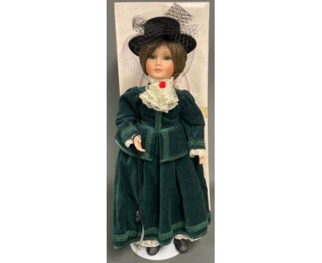 A Zasan bisque head doll, fixed eyes, closed mouth, brown hair, dressed in the Edwardian style wearing a black top hat with n