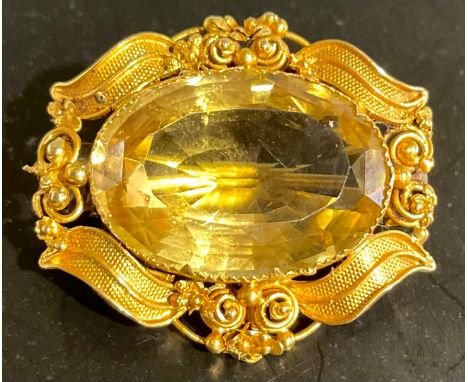 A tested 18ct gold citrine brooch,set with a pale yellow oval brilliant cut citrine measuring approx. 11.75ct, the brooch mea