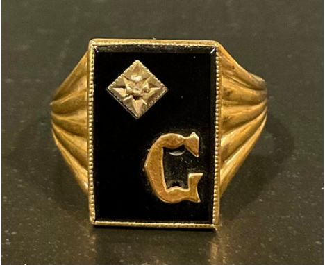 A gent's 9ct gold black onyx and diamond set "G" initial ring, set with a central rectangular polished black onyx panel appro