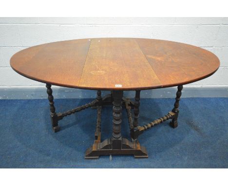 AN OAK OVAL TOP GATE LEG TABLE, on bobbin turned supports and stretchers, open length 151cm x closed length 37cm x depth 111c