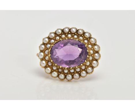 A LATE 19TH EARLY 20TH CENTURY AMETHYST AND SEED PEARL BROOCH, of an oval form, centring on an oval cut amethyst within two r