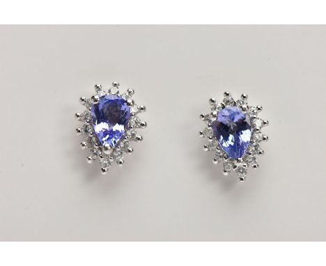 A PAIR OF 9CT WHITE GOLD TANZANITE CLUSTER EARRINGS, each of a tear drop shape, set with a central pear cut tanzanite, within