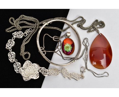 A SILVER BANGLE, TWO PENDANT NECKLACES AND A WHITE METAL BRACELET, the silver hinged bangle, decorated to one side with a fol