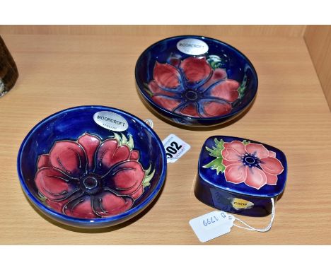 A PAIR OF MOORCROFT POTTERY SHALLOW FOOTED BOWLS AND A SMALL TRINKET BOX AND COVER, all decorated with the anemone pattern on