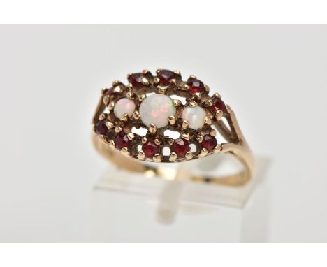 A 9CT GOLD OPAL AND GARNET CLUSTER RING, the cluster of an oval shape, set with three graduated circular opal cabochons, with