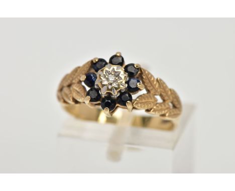 A 9CT GOLD SAPPHIRE AND DIAMOND CLUSTER RING, designed with a star set, single cut diamond, within a surround of circular cut