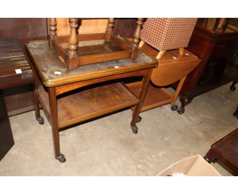 A light oak two tier drop flap trolley and another trolley.
